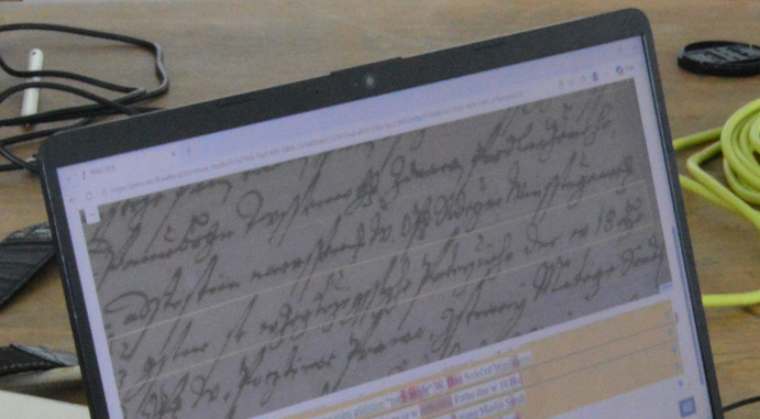 Detail monitoru s historickým rukopisem.